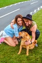 Couple playing with shar pei on the grass