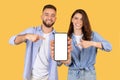 Couple pointing at blank smartphone screen, mockup