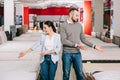 couple pointing at mattresses around