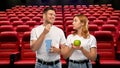 Couple with popcorn and apple at cinema Royalty Free Stock Photo