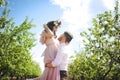 Couple portrait of a girl and guy looking for a wedding dress, a pink dress flying with a wreath of flowers on her head on a backg Royalty Free Stock Photo