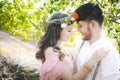 Couple portrait of a girl and guy looking for a wedding dress, a pink dress flying with a wreath of flowers on her head on a backg Royalty Free Stock Photo