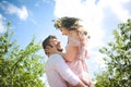 Couple portrait of a girl and guy looking for a wedding dress, a pink dress flying with a wreath of flowers on her head on a backg Royalty Free Stock Photo