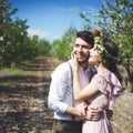 Couple portrait of a girl and guy looking for a wedding dress, a pink dress flying with a wreath of flowers on her head on a backg Royalty Free Stock Photo