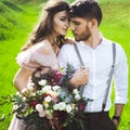 Couple portrait of a girl and guy looking for a wedding dress, a pink dress flying with a wreath of flowers on her head on a backg Royalty Free Stock Photo