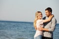Couple, portrait and hug by beach for love, peace and travel to nature for holiday. People, embrace and calm on weekend Royalty Free Stock Photo