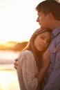 Couple, portrait and hug by beach at sunset, ocean waves and peace for romance in relationship. People, commitment and Royalty Free Stock Photo