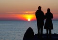 Couple, portrait of a male and female couple watching beautiful sunset at the sea, silhouette couple with sunset background Royalty Free Stock Photo