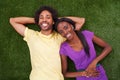 Couple, portrait and top view with smile on grass for bonding, support and outdoor date in garden of home. African woman