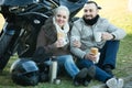 Couple posing near motor bike with sandwitches and coffee Royalty Free Stock Photo