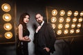 Couple posing near stage and many lamp. Luxury and richly concept.