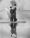 Couple posing in tuxedos and reflection Royalty Free Stock Photo