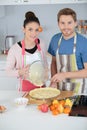 Couple pouring mixture in dough