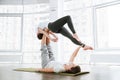 Couple practicing acro yoga on green mat in studio together Royalty Free Stock Photo