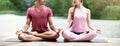Couple practicing yoga in nature near the water. Couple meditation Royalty Free Stock Photo