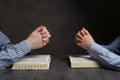 Couple praying over Bibles at grey table, closeup Royalty Free Stock Photo