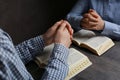 Couple praying over Bibles at grey table, closeup Royalty Free Stock Photo