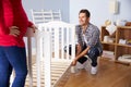 Couple With Pregnant Wife Assembling Cot In Nursery Royalty Free Stock Photo