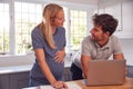 Couple With Pregnant Wife At Home Buying Products Or Services Online Using Laptop Royalty Free Stock Photo