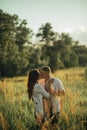 Couple with pregnant woman kisses on the meadow Royalty Free Stock Photo