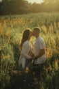 Couple with pregnant woman kisses on the meadow Royalty Free Stock Photo