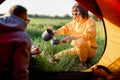 Couple prepare food while traveling with tent on nature