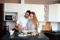 Couple preparing dough in a kitchen during daylight while engaging in cooking conversation and enjoying the process Royalty Free Stock Photo