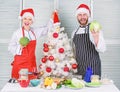 Couple preparing healthy vegetarian meal together for christmas dinner. Cooking christmas meal. Man and woman chef santa