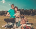 Couple preparing sausages outdoors Royalty Free Stock Photo