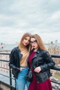 Couple of pretty women together in cityscape . Two joyful beautiful girls on roof . Beautiful city view Royalty Free Stock Photo