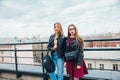 Couple of pretty women together in cityscape . Two joyful beautiful girls on roof . Beautiful city view Royalty Free Stock Photo