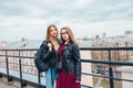 Couple of pretty women together in cityscape . Two joyful beautiful girls on roof . Beautiful city view Royalty Free Stock Photo