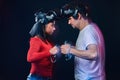 Couple of pro gamers with VR headsets participate in the game battle. Photo with light effect.