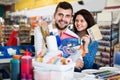 Couple purchasing tools for house improvements in paint supplies store Royalty Free Stock Photo