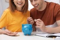 Couple putting coins into piggy bank at table. Saving money Royalty Free Stock Photo
