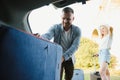 Couple putting suitcases in car trunk for a journey Royalty Free Stock Photo