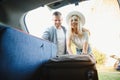 Couple putting suitcases in car trunk for a journey Royalty Free Stock Photo