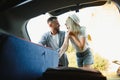 Couple putting suitcases in car trunk for a journey Royalty Free Stock Photo