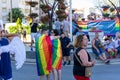 Couple with rainbow flags and people gathering in the street in gay pride day in Torremolin