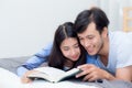 Couple reading a book together in bedroom on the morning with happiness. Royalty Free Stock Photo