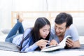 Couple reading a book together in bedroom on the morning. Royalty Free Stock Photo