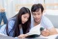 Couple reading a book together in bedroom on the morning. Royalty Free Stock Photo