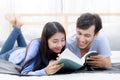 Couple reading a book together in bedroom on the morning. Royalty Free Stock Photo