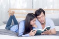 Couple reading a book together in bedroom on the morning. Royalty Free Stock Photo