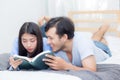 Couple reading a book together in bedroom on the morning. Royalty Free Stock Photo