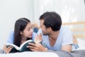 Couple reading a book together in bedroom on the morning. Royalty Free Stock Photo