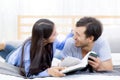 Couple reading a book together in bedroom on the morning with happiness. Royalty Free Stock Photo