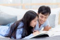 Couple reading a book together in bedroom on the morning with happiness. Royalty Free Stock Photo