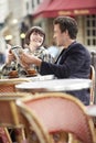 Couple Reading Guidebook At Outdoor Cafe