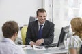 Couple With Real Estate Agent In Office